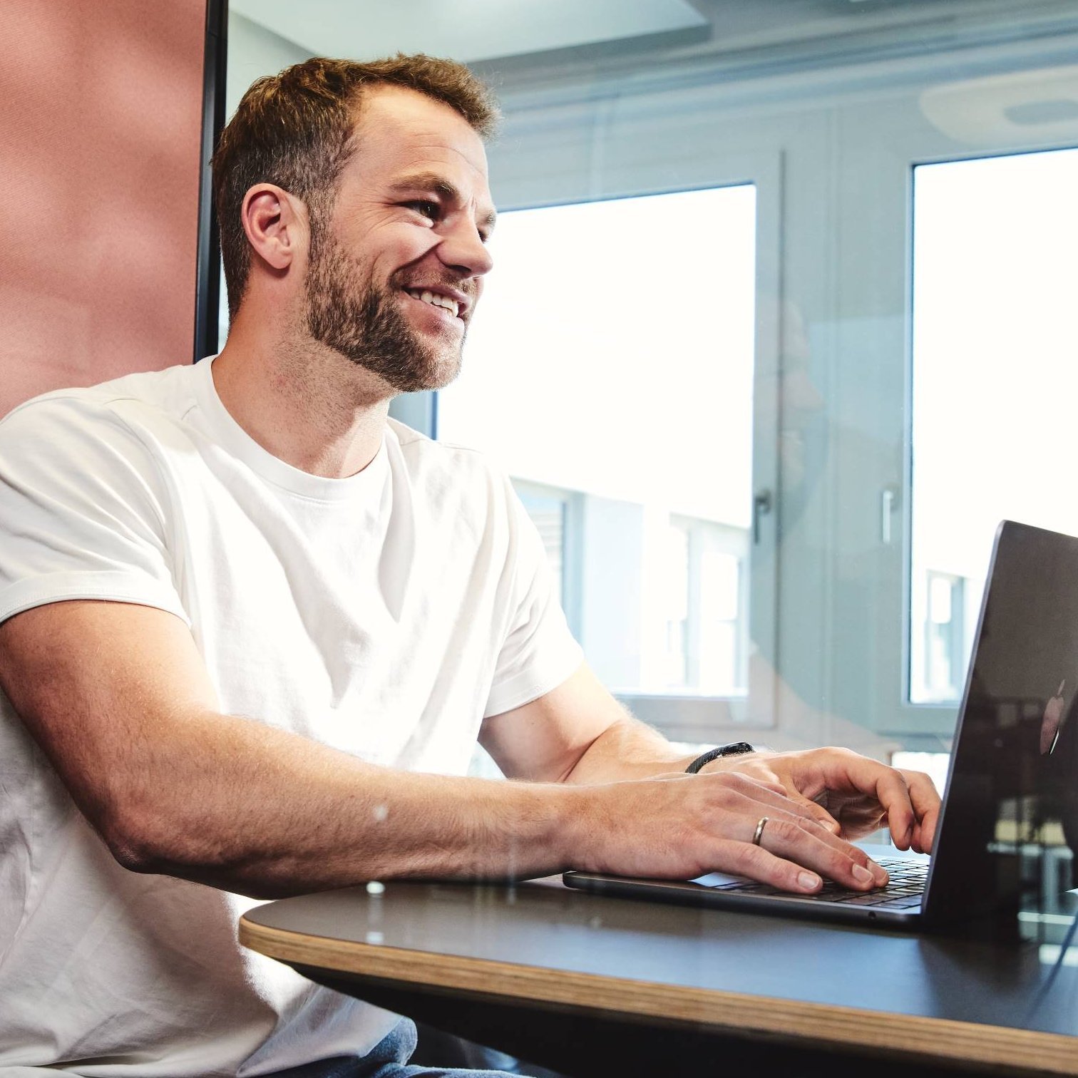 Ein lise-Entwickler in einem weißen T-Shirt entwickelt eine Software auf dem Computer