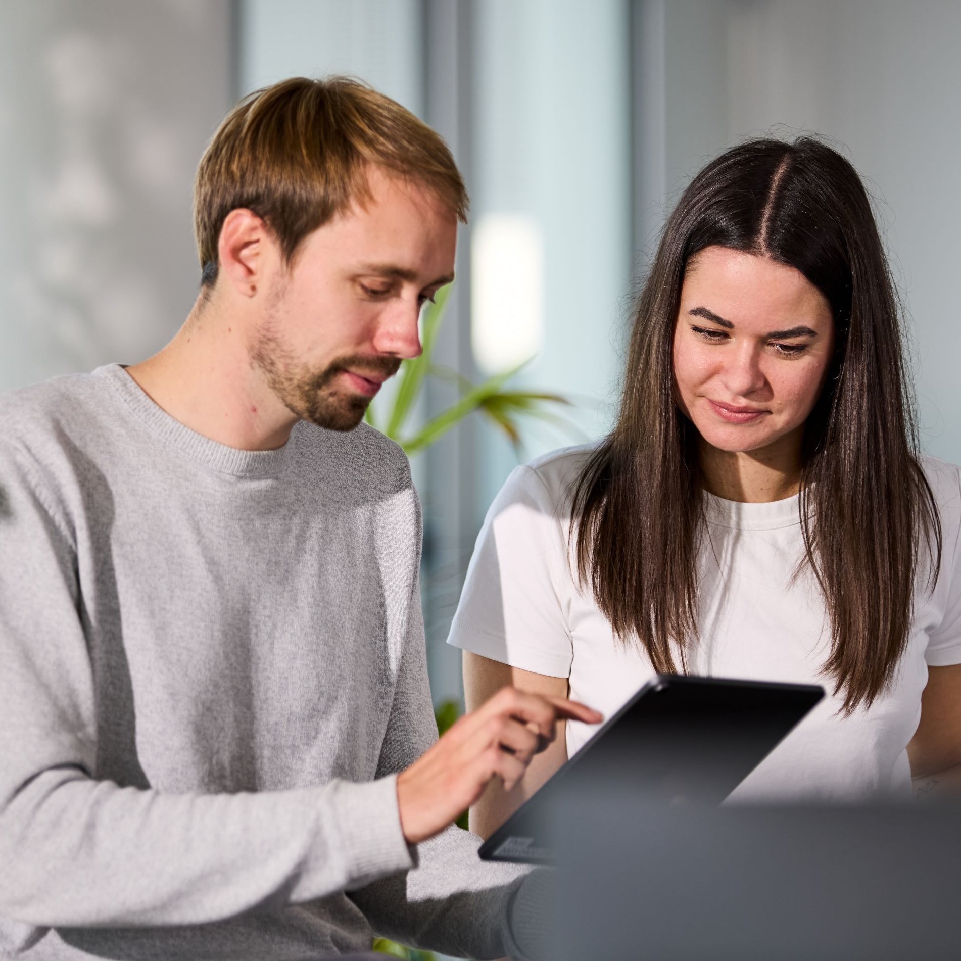 Zwei lise-Entwickler besprechen die UX-Strategie auf einem iPad