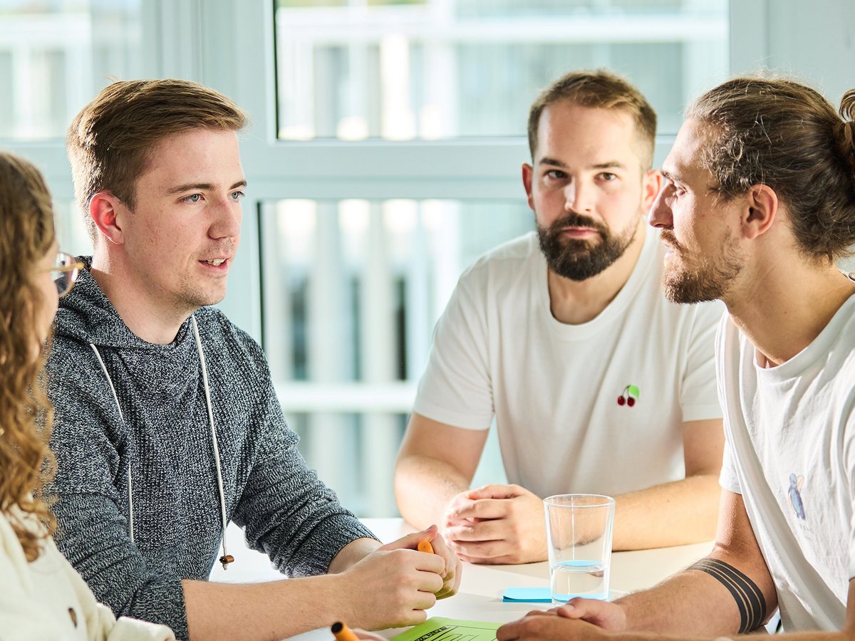 Das Method Board der lise sitzt zusammen am Tisch und tauscht sich aus, dafür liegen Stifte, Zettel und Gläser auf dem Tisch