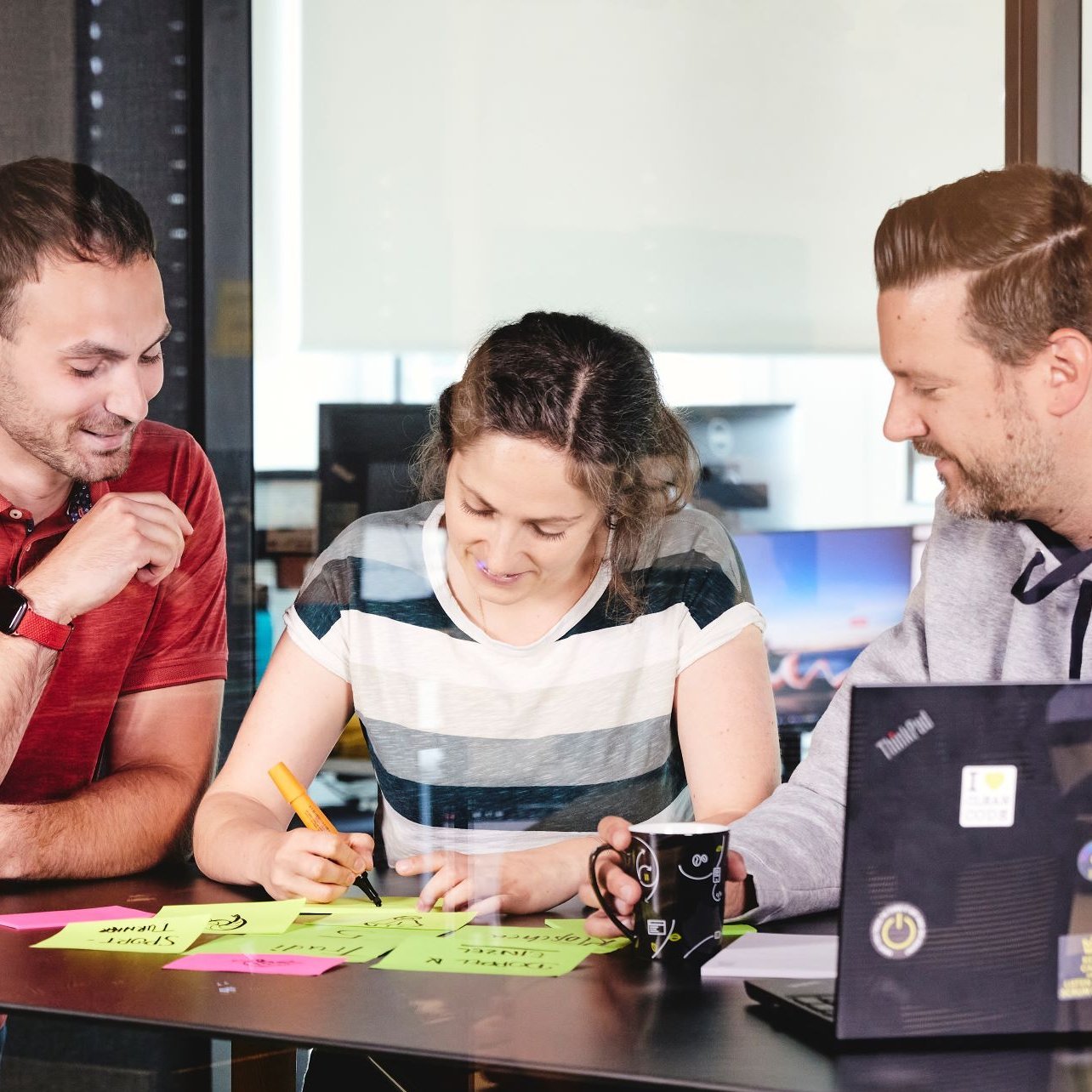 Ein kleines lise-Team hat viele Post Its mit unterschiedlichen Farben vor sich auf dem Tisch liegen, um das Coaching für ein Team zu planen