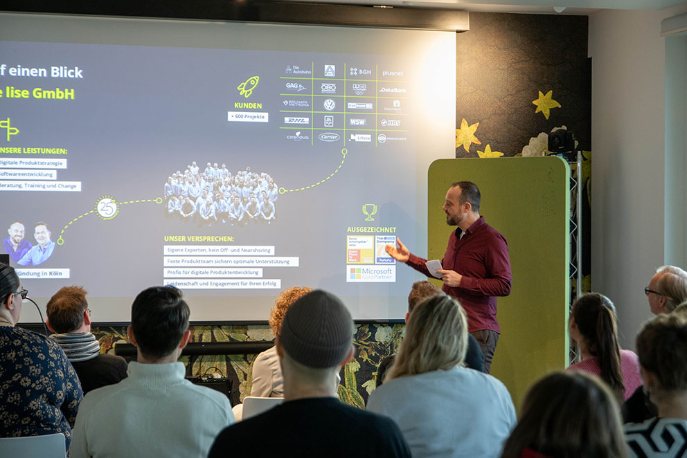 Der lise Geschäftsführer Daniel Schwarz hält vor einem Publikum beim KI-Workshop eine Präsentation.