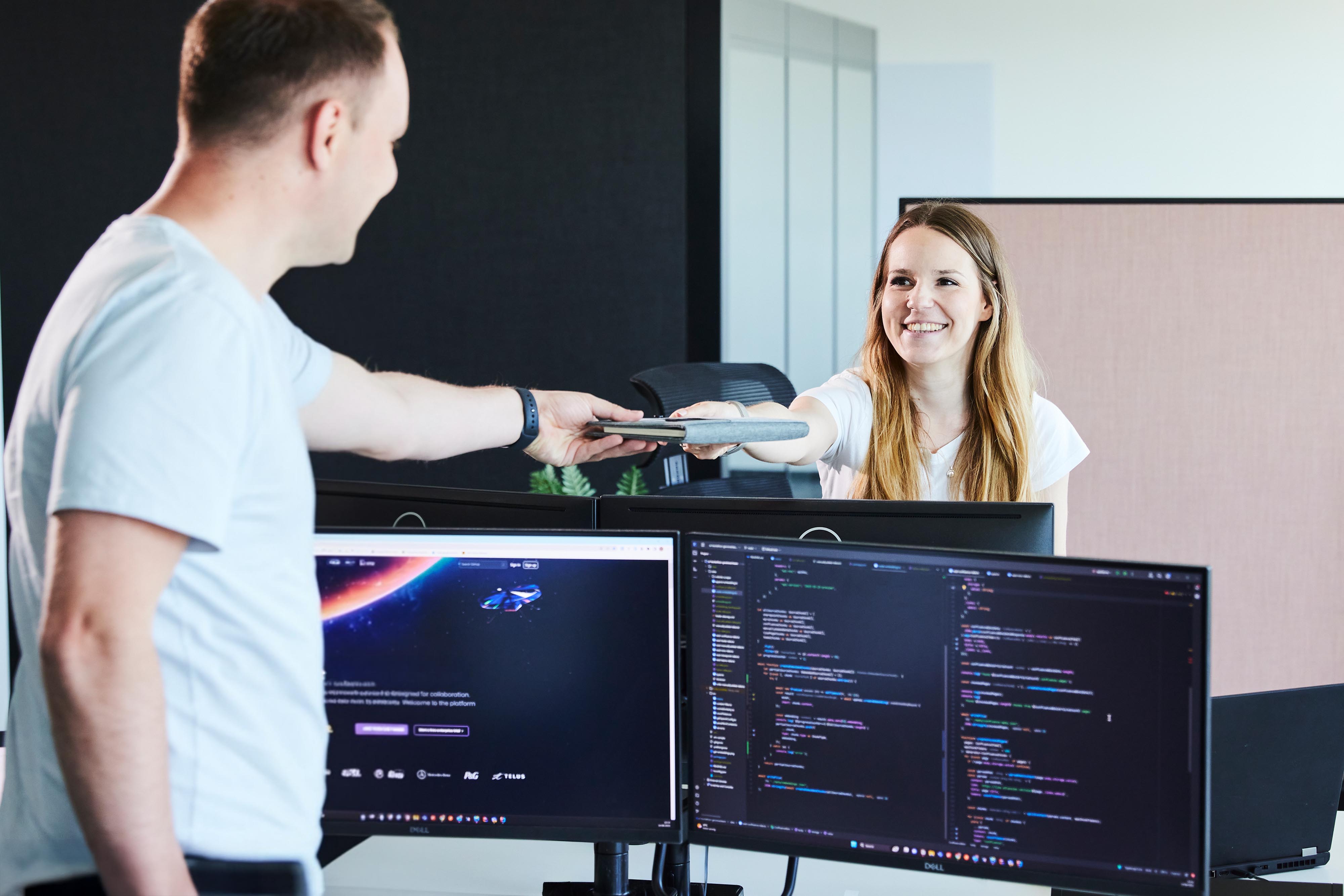 Ein lise-Entwickler übergibt einer anderen den Plan der Produktentwicklung in Form eines Notizbuches