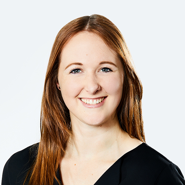 Foto einer lise-Product Managerin mit einer schwarzen Bluse und braun-roten Haaren, die in die Kamera lächelt