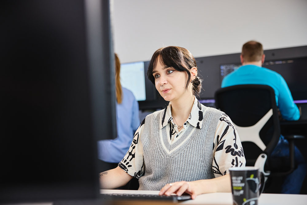 Eine lise-Entwicklerin nutzt einen KI-Chatbot auf dem Computer, um produktiver zu arbeiten